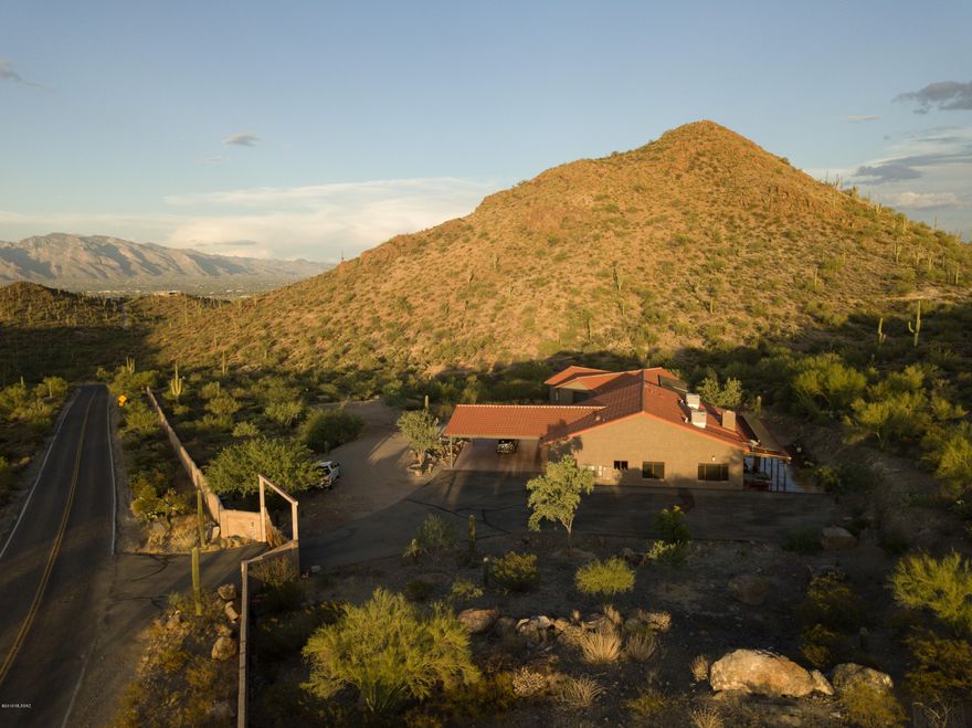 Unrivaled compound on 11.91 acres sits behind a private gate with masonry wall.Car collectors paradise with gargantuan five car garage including RV bay & ample storage plus portico for an additional 3 cars.A delight to entertain in the completely updated gourmet kitchen & living space.The great room flows into the expansive covered patio through three paneled floor to ceiling Glass Arcadia doors. Formal dining room can comfortably host your largest gatherings.Guest quarters with separate entry. Features include:owned solar system,hardwood & stone flooring,barn doors,home security system,intelligent thermostat,wood burning fireplace,custom blinds with blackout shades, pivot glass front door.Saguaro studded horse property is near premier hiking/biking trails in Sweetwater preserve.
