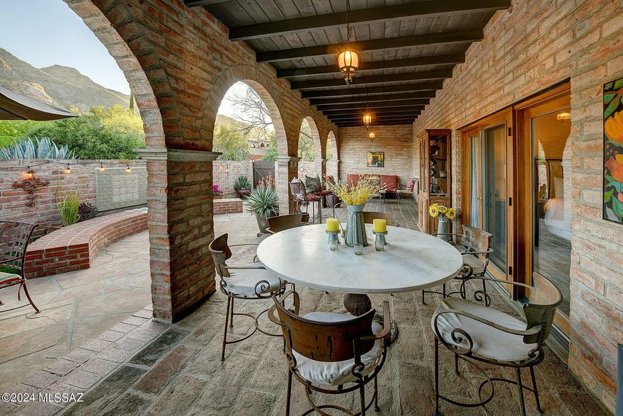 That rare blend of adobe charm, yet updated to perfection. Picture a welcoming wrought iron entry that  leads to living spaces that exemplify the casual Tucson lifestyle. Custom kitchen with seating that calls for everyone to gather.  Wall of glass doors lead to brick patio with amazing views of the mountains.  The primary suite echos the same feel with glass doors also leading to the patio.(outdoor living room?) The den could be 3rd bedroom, but what a shame except for the occasional guest.  Think glass french doors opening to the great room area.  However, a Jack and Jill makes both of these rooms flexible.  The ensuite bathroom for the primary is perfect.  I could go on but if classic simplicity is what you want....  I don't think in 30 years of real estate I have seen better.