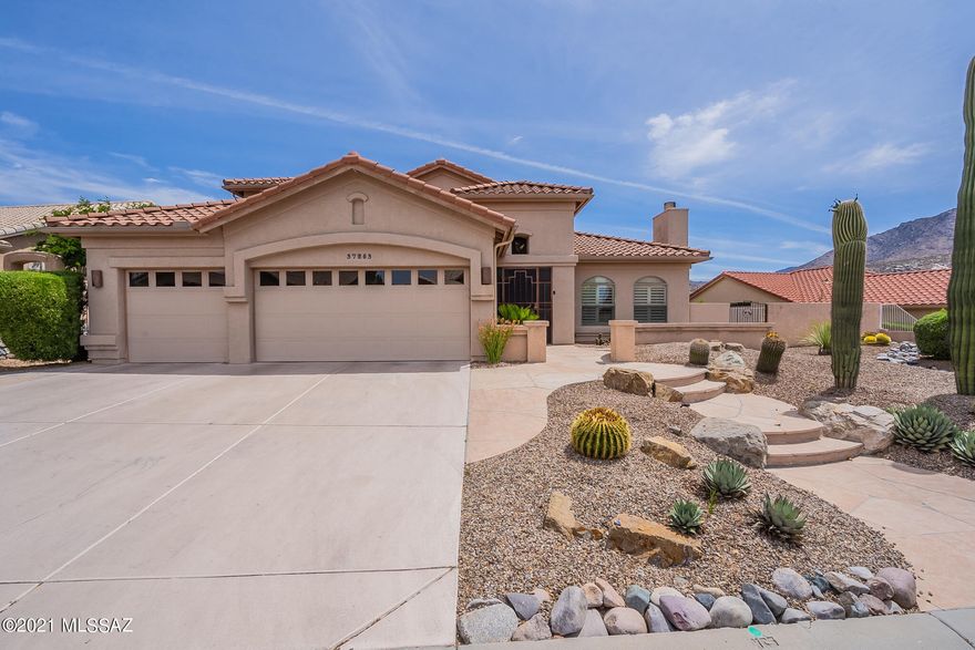 Beautiful ''Durango'' model borders open desert with views of the Catalina Mts. This popular plan is ideal for entertaining with a butler's pantry off the kitchen offering extra storage & counter space and a wine cooler. The gorgeous kitchen features a large island, granite counters, stainless appliances, cherry cabinets, double ovens, and 5 burner gas cook top.  Enjoy the mountain views from the kitchen, family room ,master suite and patio. Elegant  open staircase leads to the 2 guest bedrooms and full bath.
Expanded flagstone patio with a wood burning kiva fireplace enjoy the privacy & serenity of the open desert space.  Located in unit 21 close to The Preserve.