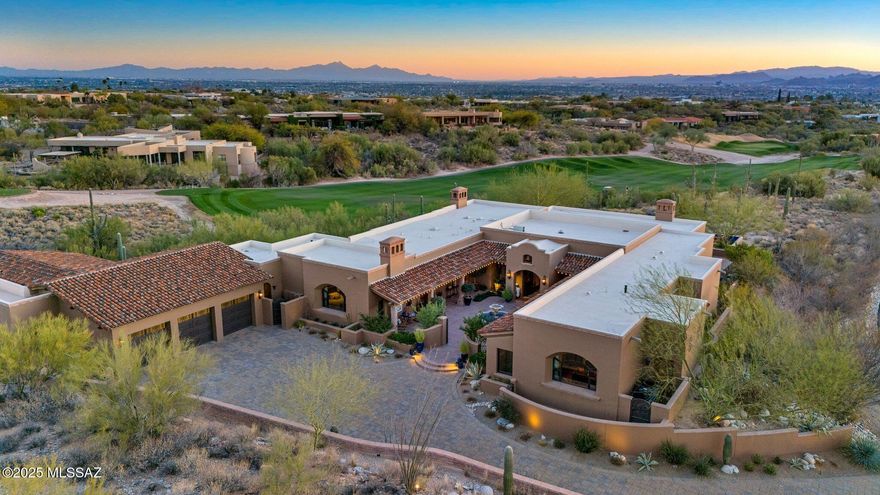 Inspired by world travels, Hacienda De Recuerdos exemplifies the charm and exquisite craftsmanship found in Missions and Haciendas throughout Mexico and Spain.  Set on one of the finest lots in the Catalina Foothills, this 6,300 square foot home has 5 bedrooms plus a guesthouse.  The lot remained protected by the Murphy Trust until Mrs. Murphy's passing in 1997.  It was decidedly the most desirable lot released at her passing for its unobstructed mountain and city views surrounded by open space and golf course on all sides.  The owners then spent the next decade designing and gathering inspiration for what has become the ''Home of Memories''.  
The entry courtyard welcomes you with its Cantera fountain at the center with traditional plantings of Palm (Martyrdom), Cypress (Eternal Life), and Olive (Peace) inspired by the Monastery in Montserrat, Spain.  The custom hand carved front entry doors from Guadalajara are overhung by a bell recovered from Fort Townsend and is an elegant way to announce your arrival.   The Azulejo on the courtyard wall originates from Spain where it was commissioned in Sevilla before finding its home in the courtyard at Hacienda De Recuerdos.

Enter into the large formal living and dining room, allowing your eyes to immediately pass through to the stunning views of the Tucson valley through the 16-foot wall of windows. These windows can vanish into the wall to allow flow from inside to outside.  The large overhead exposed beams are structural, allowing the owners the ability to maximize the ceiling height. 

Before you reach the kitchen, stop by the temperature-controlled 420 bottle wine room noticing the unique vaulted brick ceiling.  Opposite the wine room is the bar with built in beverage fridge and ice maker concealed behind matching cabinet doors.  
The family room and kitchen share space creating an open feel with a unique brick barrel ceiling inspired by those found in Barcelona, Spain.  The kitchen is highly customized with hand carved wood paneling and accents on the island and stove hood and features high end appliances from Sub Zero, Viking Professional, Wolf, and Fisher Paykel.  The primary sink overlooks the golf course. With the additional prep sink on the island there is room for family & friends to help with the holidays in the expansive kitchen. 

Adjacent to the kitchen is the home's laundry room which doubles as a second prep kitchen with a large island, refrigerator and additional dishwasher that is great for catering parties.  In the style of the home, all appliances are hidden by matching cabinet fronts including the washer and dryer.   This space also has a built-in desk and cabinets that line the walls providing ample storage.  From here you have access to the side yard and breezeway to the garage and guest house. 

The living spaces are served by an elegant half bath featuring a special beam and brick ceiling with craftsmanship from across Mexico.  The antique cabinet came from San Miguel De Allende while the copper sink was crafted in Santa Clara Del Cobre.  Like all bathroom tile throughout the home, those featured in this bathroom were imported from Mexico.

A vaulted hallway welcomes you to the spacious master suite that runs along the entry courtyard.  The bedrooms grand window directs your gaze to the Catalina Mountains and Finger Rock.  The suite features beam ceilings and a gas fireplace.  The Master bath is well thought out with separate vanities and two walk in closets with custom closet systems.   The soaking tub and makeup area feature tile reminiscent of the plaster walls at the Alhambra located in Granada Spain.  A pocket door provides privacy in the separate toilet room with a bidet.

The second bedroom in the main house was designed as a guest suite with its own ensuite bath, dual vanities, and large walk-in closet.  There are three additional bedrooms in the main house that can be closed off by a privacy door and currently serve as offices. As you enter the hallway to the guest/office wing you will observe the herringbone brick ceilings and large wood beams.  The custom light fixtures throughout the home were almost exclusively made in Mexico from the owner's designs including those in this hallway.   One office features its own ensuite bath, while the other two share a bath.  Currently closets in bedrooms 4 and 5 are merged to provide a workroom for the office. They could be converted to individual walk-in closets if desired.  El Jefe's office features beamed ceilings and stunning views of the Catalina Mountains though a grand window. 

The guest house has its own entry off the North side of the home and driveway featuring a private patio with a stone cactus fountain and stunning views of the Catalina Mountains.  Enter the guest house to find a lovely living room with a picture window to the mountains and plenty of living space.  The kitchen rivals most homes with ample storage and a large kitchen peninsula.  The generously sized bedroom has views over the golf course.  Your guests may never want to leave.  

The guest house can also be accessed through the garage, making it a short trip into the home. The oversized garage features three individual custom-made garage doors with parking for 3 cars plus space for a golf cart or room for a workout area as currently used. Additionally, there is a large, air-conditioned workshop in the garage, 1 large storage room, and 4 smaller storage closets.  

Access from the garage to the rest of the home is completely flat with no stairs throughout.  Even the backyard features a ramp to the pool level so that the whole home is accessible no matter one's time in life.  The side of the home has a private jacuzzi area that overlooks the golf course.  It also has a yard of artificial turf, great for the dog or a game of bocce ball.

The backyard is a place of tranquility and amazement.  On a clear day you can see multiple mountain ranges looking Southwest all the way to Kitt Peak.  With wide open views, legendary Arizona sunsets abound after a day relaxing by your heated saltwater pool.  The pool is flanked by two stone cactus fountains and multiple lounging areas.   The covered patio starts on the west with a fountain built with reclaimed bricks from Holbrook Arizona and a large sitting area with an outdoor fireplace.   Enjoy al fresco dining while enjoying the twinkling city lights. On the East side of the patio overlooking the golf course is the outdoor kitchen built with the same reclaimed brick featuring a large grill, side stove, sink, and bar seating. 

This one-of-a-kind home is now ready for you to create your own memories.