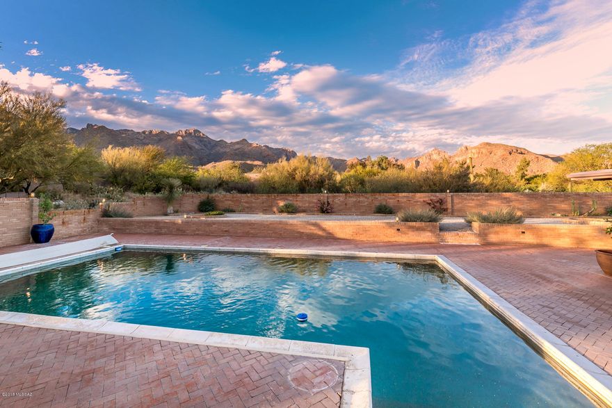 Stunningly remodeled double brick 4BR home with majestic mountain views! Nestled on a private 1.5 acre saguaro studded lot within walking distance to Sabino Canyon and District 16 schools. $290,000 +/- in recent renovations! Beautiful new gourmet kitchen with Kraftmaid cabinetry, Taj Mahal quartzite counters and Jenn-Air appliances. Spacious open great room with high ceilings and new fireplace. Gorgeous new wood-look porcelain tile throughout. Totally remodeled 3.5 luxurious bathrooms. New doors and new light fixtures. Some new dual pane Milgard windows. New 19 seer Lennox HVAC system. Enjoy the great outdoors with large covered patios, refreshing pool and panoramic mountain views. MUST SEE amazing 3D showcase, interactive floor plan and list of renovations. Oversized 2 car garage. The floor plan and 3D Showcase (Matterport) can be found in the virtual tour link in the photo tab. Please note that the assessor shows the home having 4237 SqFt. Floor plan company shows home having 4038 SqFt. 
Yearly Rudasill Road maintenance fee is $109. Ths is a Cartus Relocation. Please us the Cartus Standard Addendum (in attached documents) when submitting an offer.