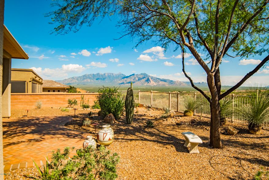 If views are important to you, look no further.  This outstanding Dragoon floor plan sits high on a bluff overlooking the 18th hole of the Canoa Ranch Golf Club with mountain & golf course views as far as the eye can see.  And, it comes with a hard to find 3-car garage!  Inside you'll find all the upgrades you'd expect of a home of this caliber:  granite counters & upgraded cabs in the kitchen; beautiful ceramic tile in all the right places; gas beehive FP and so much more.  In back you'll find spectacular views, and paver patio in the large yard.  Don't wait...good homes are moving FAST!