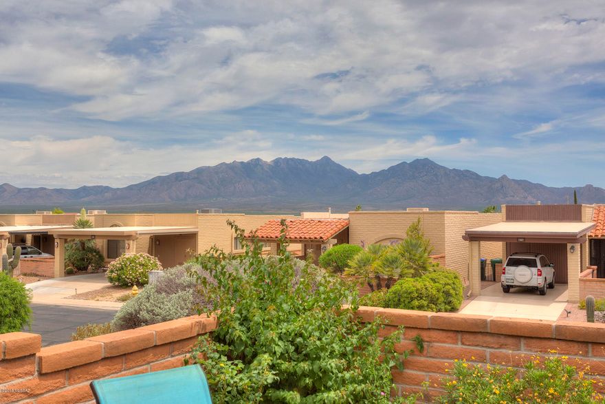 Enjoy the fantastic mountain views from the back patio of this end-unit townhouse in Desert Hills.  This home features wood-look ceramic tile through out, extra custom cabinetry in the kitchen, newer counter tops and solid surface sink. The living room and master bedroom are extended adding lots of extra living space. The retractable awning on the back of the home provides a little extra shade when you need it and awnings on the east facing windows keep the home cool in the morning.  The garage door on the carport gives you  privacy and the front sitting area has a patio cover and draw-down sun shades. This is a desert jewel you don't want to miss! Some furniture available on SBOS.