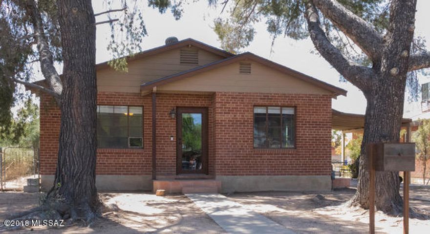 A stone's throw from both Banner and the U of A this home has a location and features that are unmatched.  Start with the main house, a brick bungalow style three bedroom one bath home with beautiful concrete flooring throughout.  The kitchen features knotty pine cabinetry for plenty of storage and a great amount of granite counter space.  The dining area connects to the spacious living room with recessed lighting throughout for a bright and clean feel.  Newer HVAC and roof work make this an unbeatable deal.  The Guest house is a southwest style two bedroom, one bathroom gem with a great room concept. The huge kitchen has more than enough storage and tiled living room is open and airy with high ceilings. Add in a laundry room and AZ room with private alley parking and access, separate utilities (aside from water), newer HVAC, and you've got an investment or rental opportunity that will move fast.  Come see it before it's gone.