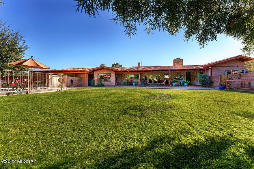 Location, Location, Location. Unique Mid Century Style home sits on almost an acre of land in the prestigious and historic Colonia Solana neighborhood.  Located near Reid Park, Zoo, tennis courts and golf courses.  Nearby is HI Corbett Field, El Con Shopping Center, and minutes to the UofA.  Easy access to downtown and all parts of Tucson for work or enjoyment. Only Two owners have owned this gem for more than 30 years each. Oozing with Charm, upon entry you will observe the rich and warm walnut paneling throughout the house into the bedrooms. The family room has a gorgeous wood burning fireplace, tiled floors, Ceiling fan, vaulted wood ceilings, surround sound and French doors leading to the rear yard. Backyard oasis with an amazing sports pool and spa, oversized covered patio, badminton sized grass area, beautiful flowers, shrubs and citrus trees. 
Formal dining room with wood floors, vaulted wood ceiling, hand crafted double wood doors from Bali and custom paint. The room looks out to the front of the home which is decorated with a long standing bounty of various cacti including Saguaro, golden barrels, elephant prickly pear, and large century plants.
The wrap around large kitchen is in pristine condition with Stainless steel Kitchen appliances: including a sub zero refrigerator, dacor 5 burner gas cooktop w/ magnificent copper hood. Kitchen Aid dishwasher, wine fridge, Dacor built in oven and microwave, two sinks and an indoor grill w/copper hood.
Fully remodeled master bath includes a royal free standing bathtub, walk in shower with tile surround, glass door and a steam room. Custom vanities, undermount sinks, new fixtures and framed mirror medicine cabinets.
Potential Guest House- The large storage building could be easily converted to a guest house. It has electric and plumbing. Great opportunity for AirBnB investment dollars. 
Extra Features: Built in Outdoor BBQ, 2 newer AC units. Security cameras, Village Blacksmith crafted the security doors, fireplace screen and drapery rods. 4 ample storage rooms, large pantry, laundry room, Circular driveway w/ parking for 15 plus cars. Property tax benefit given to historic designation.