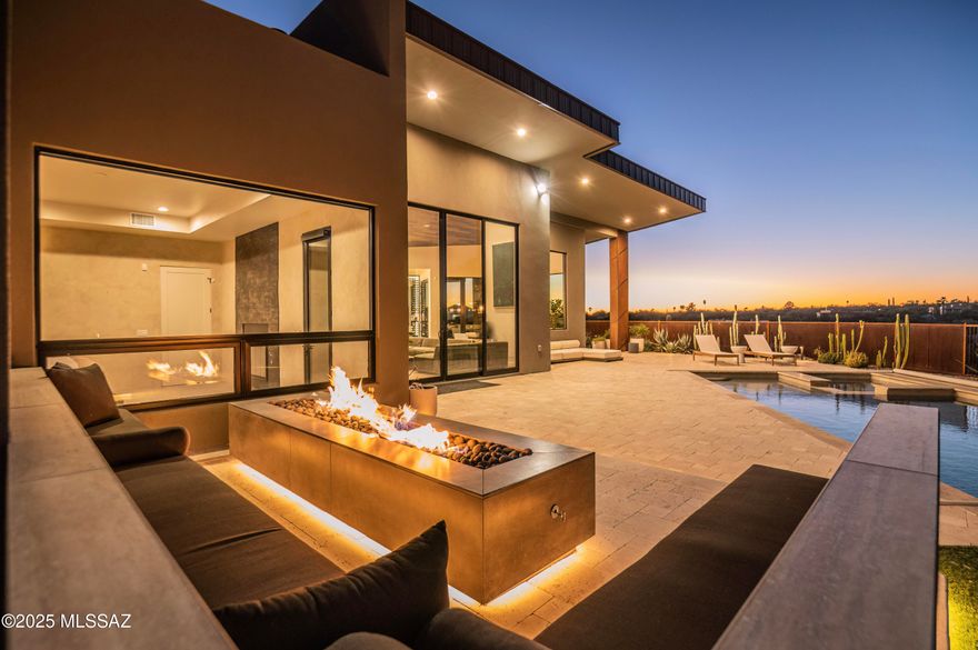 Established in Tucson's premier Catalina Foothills, this extraordinary contemporary residence embodies the very best of craftsmanship, custom finishings and refined desert living. The expansive picture windows fill the open living spaces with natural light, seamlessly blending the indoor and outdoor 360° panoramic views. The gourmet kitchen features stunning marble countertops, a large center island, and top-of-the-line stainless steel appliances. The serene primary suite includes a fireplace and spa-inspired bath area paired with stunning mountain views. Entertain and accommodate guests with the pre-installed Sonos sound system, smart heated pool and spa with automated safety cover, firepit lounge, and extended 3-car garage. Located near premier shopping, dining, and entertainment.