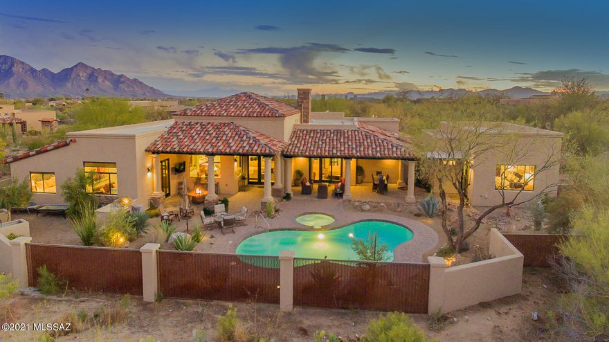 This stunning SW contemporary is located in the prestigious gated community of Stone Canyon offering 4,139 sq. ft. Enjoy this luxury home boasting 3 ensuite beds w/ office & private guest quarters. This private community offers resort-like lifestyle w/ Championship-level golf course, clubhouse, & more! Enter thru lushly landscaped courtyard to custom rustic iron/glass doors. Open design offers natural light & jaw-dropping mountain views perfect for entertaining w/ inviting fireplace in great room leading to gourmet  kitchen w/ Quartzite countertops & SS appliances. Beautiful marble & Karastan Villa Pointe wood flooring throughout. Spacious master suite offers sunken tub, walk-in steam shower, & custom glass doors leading to patio. Backyard w/salt water pool, spa, & built-in BBQ!