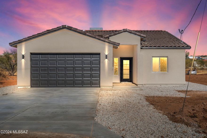 Discover modern living in this stunning newly constructed 4-bedroom, 2-bath home located on a peaceful cul-de-sac in Rio Rico, Arizona. This thoughtfully designed home features sleek tile flooring throughout, complemented by elegant white cabinetry and quartz countertops. The heart of the home is the gourmet kitchen, complete with a waterfall island that's perfect for entertaining. Nestled in a serene setting, this home is a must-see for those seeking style, comfort, and convenience.