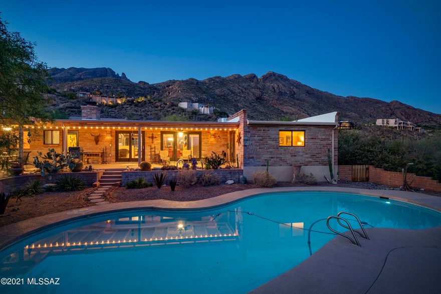 Beautiful adobe home with the classic architecture you'll love.  Exposed brick, concrete floors, yet tastefully updated.  Two owner suite's, and two additional bedrooms.  Enjoy the city lights as you overlook the tranquil pool area from your long covered patio, and the Catalina mountain views and Finger rock from the front of the home.  Nestled in natural desert landscape, the home is secluded yet minutes from your favorite amenities.
