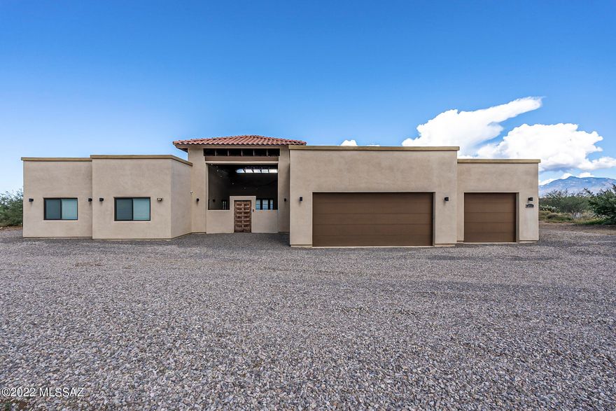 Beautiful home on 5 acre lot with expansive open concept living/kitchen space. Great room with 11ft high ceilings & in wall surround sound system. Built in microwave/oven combo, induction cooktop, lots of cabinet storage space and enormous island. Concrete overlay flooring & 36'' solid wood doors throughout the house. Amazing master suite w/walk in closet, dual shower head & flex room connected. Has it's own ext entrance & .5 bath. Oversized 28' garage and huge fenced backyard and covered courtyard. On the other side of the split floorplan you will find 2 bedrooms & a 2ND KITCHEN and flex space. Sellers have rented this space for $1200/mo. Own ext entrance. NO HOA. Sellers are offering 1 point buy down toward your interest rate. SELLERS COMPLETING PAVING RD.