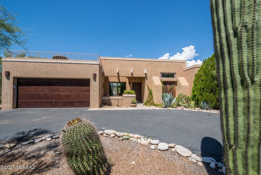 Wow! This stunning southwest contemporary with gorgeous mountain views, dramatic sky high wood beamed ceilings, massive stone fireplace and fabulous lushly vegetated and private lot with oasis like backyard is a must see.  Kitchen features rich raised panel cabinetry, granite tile counters, designer tile backsplash and stainless steel appliances.  Both baths have phenomenal tile work, dual sinks, and awesome cabinets. Generous back patio lives like interior space and leads to the pebble tec pool with lots of decking and incredible views. Other features include formal dining, circular driveway, wonderful architectural details, very cool & spacious viewing deck with spiral staircase boasting lovely city lights and more mountain views.    Garage has extra space for workshop/storage area.