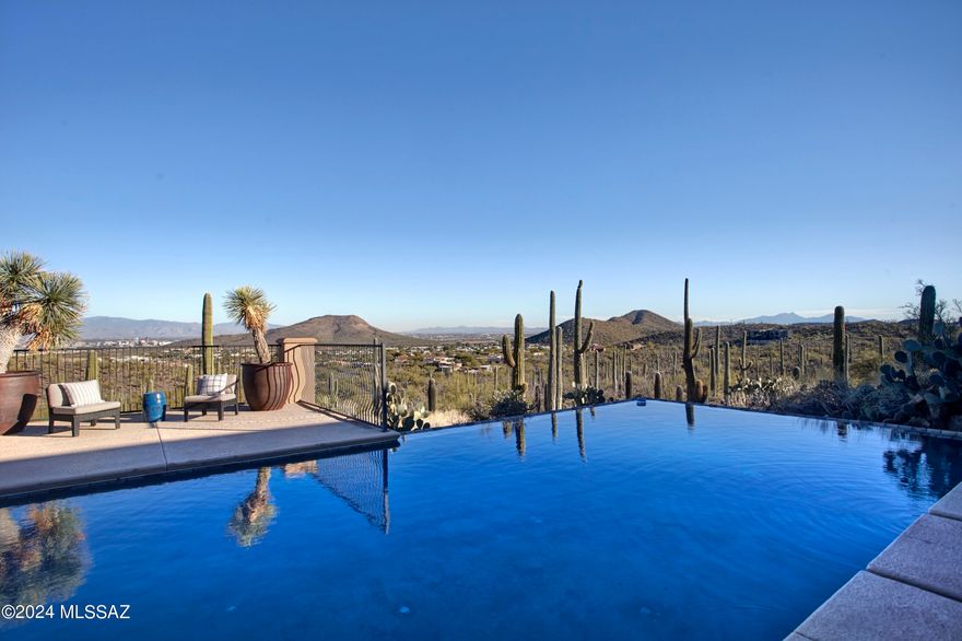A desert oasis near Downtown Tucson, AZ. Sitting high on a 3.3-acre lot with incredible views of the desert, mountains, and city lights, 380 N Resort Hills Place awaits. With only a few other luxury homes in this small, gated enclave, the setting is incredibly private, while the city and lifestyle amenities are easily accessible. Being sold by the original owner, this property was built to the highest standards.  Both the indoor and outdoor spaces were thoughtfully crafted and positioned to maximize the residential experience. The 4,977 square foot home showcases timeless beauty and elegance. Stone floors, custom millwork, solid doors, expansive glass, and iron blanket the space. Allowing for a variety of layout possibilities, the home includes 5 bedrooms, 5 full bathrooms (including a pool bath), an office, gym and 2 half bathrooms. Windows were carefully placed to maximize views from every room. Naturally set up for entertainment, the kitchen and living spaces flow seamlessly to an expansive covered patio, allowing for large gatherings.

Outdoors, the Tucson lifestyle is truly showcased. Wrapped by a saguaro studded hillside with layers of landscape, there is a deep connection with the desert. A variety of zones, either poolside or along the terrace, create natural spaces for lounging, dining, or entertainment. Tucked away, an area with synthetic grass creates the perfect place for yoga or pets.

The extended 3 car includes a workshop area, an AV room and storage closets.

This location offers quick access to a variety of conveniences and would also work well for commuting or regular air travel.  Immediately available are multiple trailheads with access to the magnificent Tucson Mountain Park for hiking, mountain biking and trail running. The Starr Pass Resort provides 3 golf courses designed by Arnold Palmer, Phil Mickelson, and Nancy Lopez, along with fitness facilities, a full-service spa and dining. Downtown Tucson is a short drive, offering residents city life with robust restaurant offerings, unique shops, cultural events, and festivals.