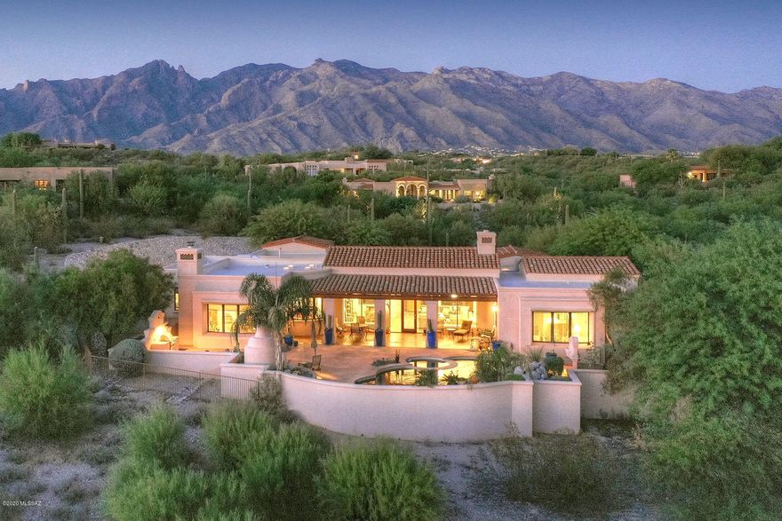 Beautiful Cat Foothills 10, Kevin Howard exquisitely designed Spanish Mission 4556 sqft Masonry home. Perfectly sited on a corner lot w/City lights & forever Mt.Views. Enter thru charming courtyard into elegant living room/dining area w/FP & dramatic 17' wood beamed Cathedral ceilings. Pella windows/drs, sep kitchen-greatroom w/FP, new SS Kitchenaide range, doubleoven & dishwasher. 4 bdrm, split floor plan, 4th bedrm is office w/its own entrance. Cherry cabinetry thruout. Recent upgrades incl. whole house evaporative coolers, instant hot H20, UV Air Purifiers, built-in bookcases, Sunscreens, Security Screen doors, repainted interior, new carpet, Patio mister system, Auto lighting & more! Stunning xeriscaped backyard w/pool, spa, FP,BBQ, separate fenced yd. XL 3 car garage.