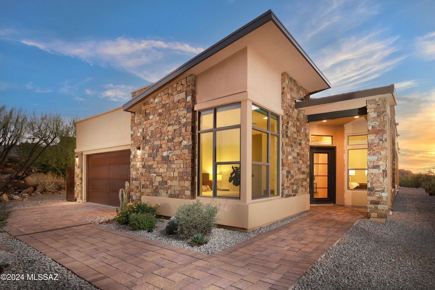 Set amidst striking rock outcroppings and towering saguaros, this prime cul-de-sac location offers unparalleled privacy, with your lot bordering a conservation easement for the ultimate in serene desert living.
Located in the beautiful gated community of Boulder Vistas at Stone Canyon. 
The paved driveway leads to a Contemporary entryway featuring stacked stone and metal accents. Interior lighting all replaced with Restoration Hardware for that polished modern look. A split-bedroom floor plan maximizes space and functionality, offering a perfectly sized home without compromising comfort. The upgraded kitchen serves as the heart of the home, boasting an oversized quartz island with breakfast bar, stainless steel appliances, a walk-in pantry, (click more) custom cabinetry and under cabinet lighting. An adjacent formal dining area is complemented by a bar room, complete with a wine cooler and extra storage.
The open-concept great room features large scale tile floors and walls of windows, perfectly framing the uninterrupted views. A large retractable glass door seamlessly transitions the indoors to a deep, covered wraparound patio complete with outdoor electronic shades, , offering a peaceful space to relax or entertain. The backyard is enhanced by beautiful pool & spa , a concrete & glass filled fire pit, and natural boulder enclosures for added privacy.
The primary suite offers serene views and a spa-inspired bathroom with an expansive glass-enclosed shower, dual vanities with ample storage, gorgeous tile flooring, and a walk-in closet. Two additional en-suite guest bedrooms include beautifully tiled showers with glass enclosures, while a flexible den space off the entry can accommodate an office or other needs.
Additional features include a well-equipped laundry room with storage and sink, and a two-car garage.  
Stone Canyon Lifestyle(As part of the prestigious Stone Canyon community, residents enjoy access to the award-winning Stone Canyon Club, consistently ranked among the top golf courses in the nation. Beyond the 18-hole Mickelson-designed course, the club offers a state-of-the-art fitness center, lap pool, tennis and pickleball courts, yoga and pilates classes, and luxurious spa services. All this, within easy reach of restaurants,
