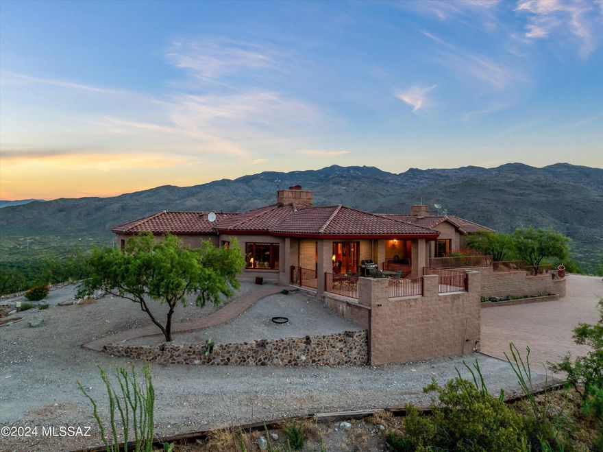 Welcome to a one-of-a-kind gated estate on a private hill in Arizona's gorgeous landscape. Enjoy 5.6 acres plus approximately 51 additional acres of adjoining land, offering unparalleled seclusion and panoramic views. This 4,039-sq-ft luxury home features 3 spacious bedrooms, 2.5 baths, a chef's kitchen with custom knotty alder cabinetry, and an open-concept living area with stunning wood beam ceilings. Breathe in the desert vistas from expansive windows and outside patio off living area. Relax by two fireplaces-pick your view!. Additional amenities include a 3,200-sq-ft detached warehouse/workshop with a 20x80 carport, perfect for storage or creative projects. Don't miss this Arizona paradise.