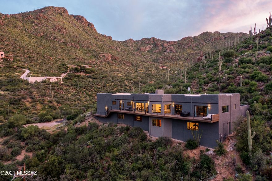 Perfect balance of luxury & nature in this beautifully updated home nestled high in Tucson Mountains in the private Trails End Community. This elegant home features floor to ceiling windows to capture some of the most breathtaking city and mountain views around. Enjoy the Chef's kitchen with professional grade appliances, huge island and a large walk in pantry. The stunning great room with beautiful fireplace opens up to the amazing deck that runs the entire length of the home. The amazing views carry through the master suite with elegantly appointed bath and all additional bedrooms which also have direct access to the outdoor deck so everyone can enjoy the majestic mountain views and dazzling city lights. Furnished Range Priced Seller Will Accept or counter offers 1,400,000 - 1,500,000 On the lower level you will enjoy the large media room with fireplace, gym and rejuvenation space with sauna, this is a great retreat or potential guest quarters. The large oversized garage features an oversized RV door and enough space for a small RV and a couple vehicles. This home is being offered with the majority of the furnishings. To appreciate what this beautiful home has to offer schedule your private showing today.