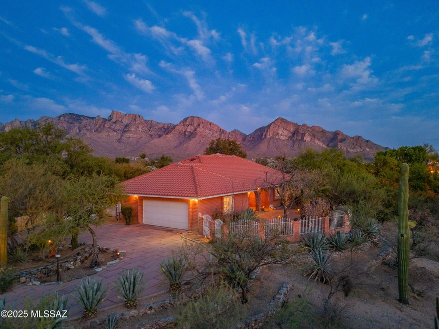 Ranch-style home in the heart of Oro Valley on a spacious 1.01-acre lot with stunning Catalina Mountain views. Located in desirable Tangerine Hills with no HOA, and adjacent to a natural desert wash for ultimate privacy. Gated front courtyard with pavers, fruit trees, and covered patio. Flexible layout with formal and casual dining, den/office, and laundry room. Kitchen features ample cabinetry, generous counters, and a coffee bar. Tile flooring and plantation shutters throughout—no carpet. Primary suite includes a walk-in closet and updated bath with barn door. Backyard oasis with heated pool, grass, mature landscaping, patios, shed, and RV gate. Oversized 2-car garage with storage and workshop space. Large circular driveway with extra parking.