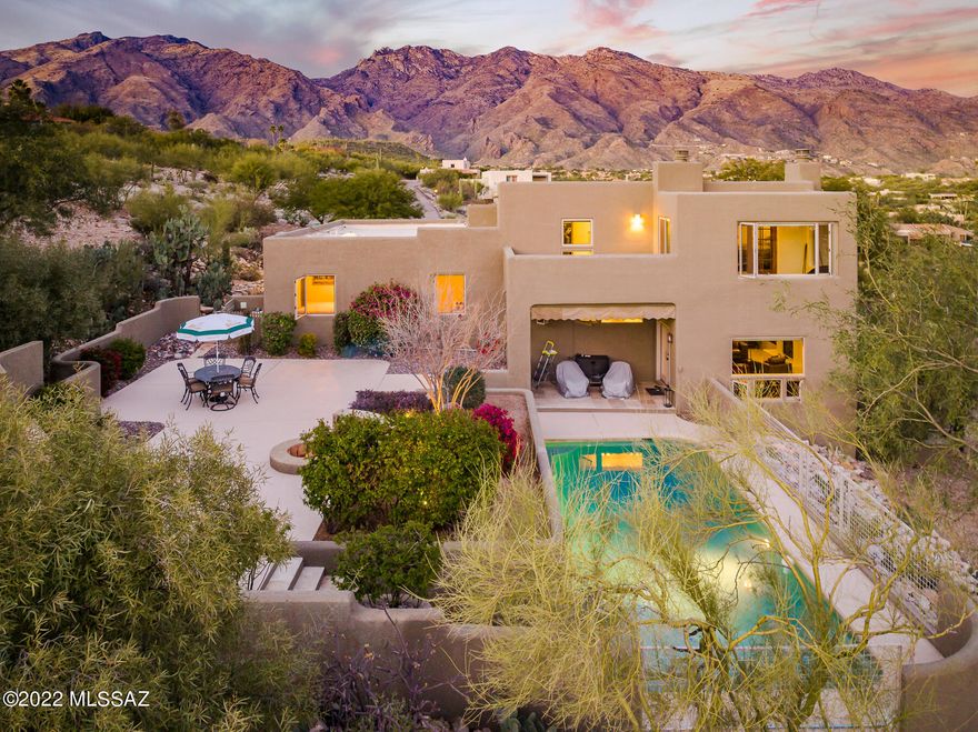 Immaculate, tastefully updated southwestern style home w/ a modern flair conveniently located in the heart of the Catalina Foothills in Cimarron Foothills Estates.   Enjoy true privacy on this  1.14 acre ridgetop lot w/ sensational mountain, city & sunset views. Distinctive front courtyard covered w/ flagstone leads to custom solid wood front door & bright entry.  Upon entry, a perfectly placed large picture window frames the sweeping views of the valley below & the natural desert.  Spacious living room w/  magnificent natural light has high, wood-beamed ceilings & an impressive fireplace. Adjacent formal dining room leads to the upgraded gourmet kitchen featuring granite counters, upgraded soft-close cabinets w/ custom built-in wine rack & glass holder, stainless steel appliances, CONT.. hammered copper dual farmhouse sink & breakfast bar.   Kitchen opens to family room w/ bar area w/ sink & stainless steel wine cooler. Split bedroom floor plan features 4 bedrooms & 3 bathrooms-each bathroom is upgraded w/ travertine slab counters, travertine tile surrounds, soft-close cabinets & newer fixtures.  Views from every window in the private master suite w/ fireplace &  135 square foot Arizona style sitting room & walk-in closet. Master bathroom w/ dual sinks, newer fixtures, separate shower w/ travertine surround tile & accent details.  Additional interior features include polished travertine floors throughout w/ carpet in bedrooms, all new Milgard windows installed in 2018 w/ 10 year warranty, new Hunter Douglas blinds throughout the home, new Bosch refrigerator & dishwasher, new Electrolux built-in microwave & upgraded laundry room w/ extra storage cabinets & granite counters.  Dreamy backyard oasis w/ covered patio, pool & firepit is completely finished w/ low-care landscape/hardscape leaving the new owner w/ nothing to do but enjoy the exceptional privacy & views.  2020 full renovation of the pool area w/ new pebble tec surface, poured concrete deck & pentair pump & filter. 2-car garage w/ brand new epoxy finish & large motorcourt for additional parking.  Major system upgrades include re-coated roof (2021), two 17-seer Trane units w/ variable speed air handler (2019), new water heater (2018), whole house water treatment system w/ RVO tap in kitchen (2020) & new exterior paint (2018). District #16 Schools including Ventana Vista Elementary w/ Highly-Acclaimed Spanish Immersion Program. Incredible Foothills Location within Minutes of the Best Shopping & Restaurants Tucson has to Offer. Close to World-Class Golf Resorts & Country Clubs and Tons of Hiking & Biking Trails including Sabino Canyon.