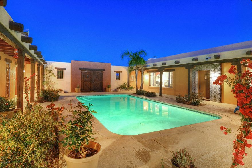 This stunning hacienda retreat is nestled in the desirable Catalina Foothills Estates and abounds with character and old pueblo charm. Situated along a ridge for beautiful Catalina Views, this private retreat provides quiet tranquil living yet is close to shopping and all amenities. A grand front entry gate with forged hardware leads into a lush center courtyard with pool and wrap around patio. The stylish interior of the home boasts Spanish mission touches w/ viga beams & pecky cypress planked ceilings, built-in niches, and saltillo tile & porcelain plank floors throughout the main living spaces. Enter into the expansive family & dining room w/ natural light that floods the open floor plan and creates an atmosphere of spacious comfort throughout the home. A beautifully updated gourmet kitchen w/ top of the line stainless steel appliances & granite countertops is central to the home w/ pass through access to the courtyard. Retreat to the master bedroom suite w/ stunning master bath that boasts marble counters, freestanding soak tub, & custom glass enclosed shower. A cozy office/library overlooks the courtyard and is a perfect place to work or relax. Guest will enjoy a 2 Bed/1 Bath separate quarters w/ kitchenette, fireplace, & private access entry off the courtyard. This home is the perfect fusion of old world Tucson charm w/ all the modern touches. Perfect location for hiking, cycling, and all Tucson has to offer.