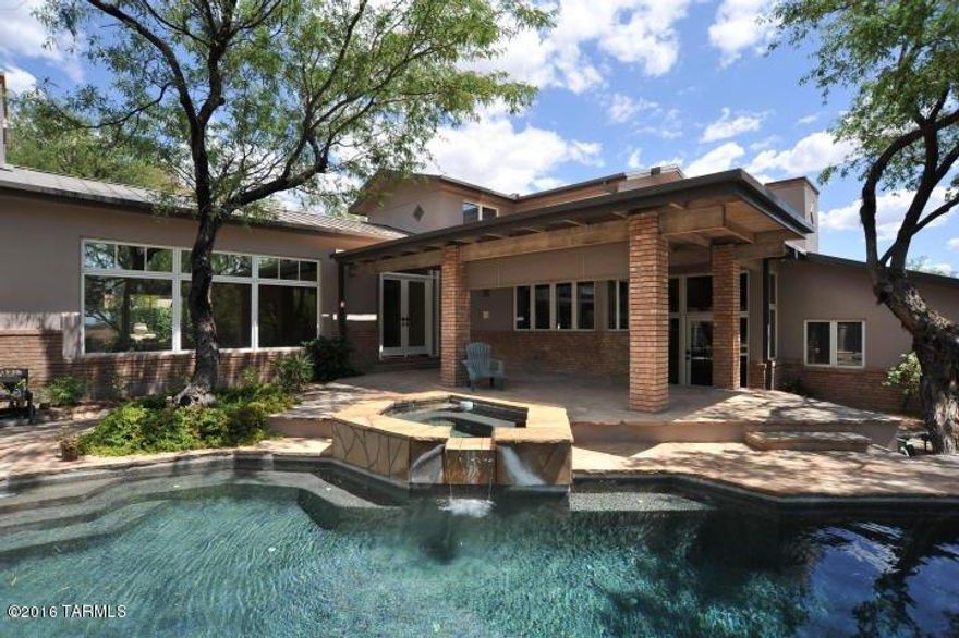 Outstanding, remodeled contemporary on the lake and golf course in prestigious, gated Ventana Canyon Estates. Designed by architect Bill Gansline, this 4 bedroom 2 3/4 bath home with metal roof features courtyard entry into living room with soaring cathedral ceiling, walls of windows and 24''x24'' travertine floors. Remodeled baths, new carpet, new knotty alder doors, gourmet kitchen with granite counters and designer appliances adjacent to cozy family room with fireplace and built-ins. Gracious master suite with his/hers closets and balcony overlooking the lake, golf course and city lights. Wonderful rear yard with lush vegetation, pool and spa and so much more. Garage has designated area for golf cart.