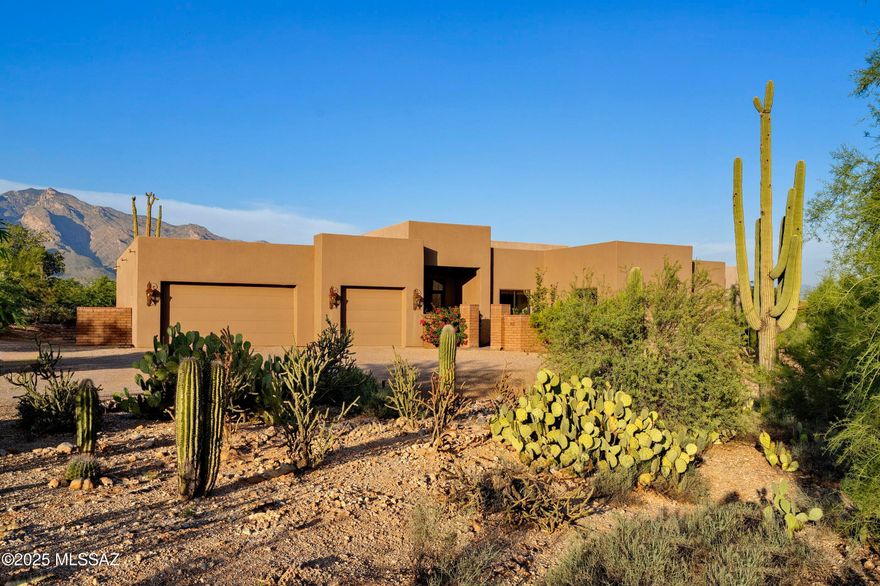 Set within the quiet and highly sought-after neighborhood of Shadow Hills, this thoughtfully designed residence embodies the essence of refined desert living. Every angle of the home has been considered to maximize the seamless indoor-outdoor connection, creating an environment that is as livable as it is visually striking. Upon entry, the home immediately reveals its intent: spaces that feel open and light, yet intimate and composed. Scored integral colored concrete floors lend a warm, textural foundation to the interiors, complementing soaring ceilings and expansive walls of glass that frame uninterrupted, large-scale mountain views of the Catalinas. Carefully curated interiors offer a balance of warmth and sophistication. Designed for both entertaining and everyday living, the layout encourages flow while providing distinct moments of quiet retreat.

At the heart of the home, the chef's kitchen is both stunning and functional, featuring a generous center island, bespoke cabinetry, stone surfaces, and top-end appliances. Adjacent, a butler's pantry provides additional prep and storage space, keeping entertaining effortless and the kitchen workflow seamless. Every detail has been considered, from materials to spatial design, creating an environment where form and function align perfectly.

The primary suite, privately situated, offers a restorative escape, framed by picture windows that invite soft, natural light and panoramic desert vistas. A serene, spa-inspired bath completes the retreat. Within the suite, a large walk-in closet provides generous storage, complemented by a second closet currently serving as a dedicated exercise room. Three additional ensuite guest bedrooms are thoughtfully positioned in the southeast wing of the residence, centered around a modern, multifunctional flex space, an inviting hub equally suited for a sleek media lounge, relaxed TV room, or vibrant communal gathering area.

Covered patios and private terraces extend seamlessly from the interior spaces, each oriented to maximize light, shade, and views throughout the day. The fully fenced backyard is a controlled, thoughtfully designed landscape, a curated composition of decomposed granite and synthetic turf, softened by lush vegetation on a fully automated irrigation system. Landscape lighting has been strategically integrated to highlight architectural lines, mature plantings, and pathways, creating an evening ambiance as compelling as the daytime views. Beyond the fencing, the property backs directly to untouched natural desert, preserving both privacy and a visual connection to the surrounding wilderness.

On the northwest side of the property, a dedicated sport court offers a versatile recreational amenity for everything from basketball to pickleball. An oversized three-car garage, recently treated with a fresh epoxy finish, provides durability, ease of cleaning, and a polished appearance.

Located minutes from Tucson's premier dining, shopping, and trail systems, yet offering a sense of being worlds away, this residence is a rare offering in one of the Foothills' most enduring communities, a home where architecture, setting, and lifestyle exist in perfect balance.
