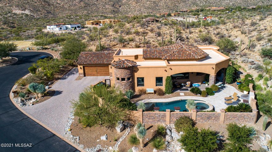 This exquisite Stone Canyon home rests on 2 acres, offering incredible unobstructed Catalina Mountain views, city lights, & end of street  cul-de-sac peace and quiet. Saguaro cacti abound. Stone Canyon amenities include world class golf, a restaurant, Health/Fitness Center, pool & guard gate entrance. The kitchen has Wolf & Sub-Zero appliances;  the granite counter tops are exceptionally beautiful. Note the central vac, the two master bedrooms & 16' ceilings. All floors are natural stone except wood-like ceramic tile in the bedrooms. Both front & back patios feature open flame ambience (see  the Big Green Egg smoker!). Note the self cleaning PebbleTec pool, waterfall slots & the stunning negative edge in-pool spa. Most furniture is available. Truly, a remarkable home to be proud of