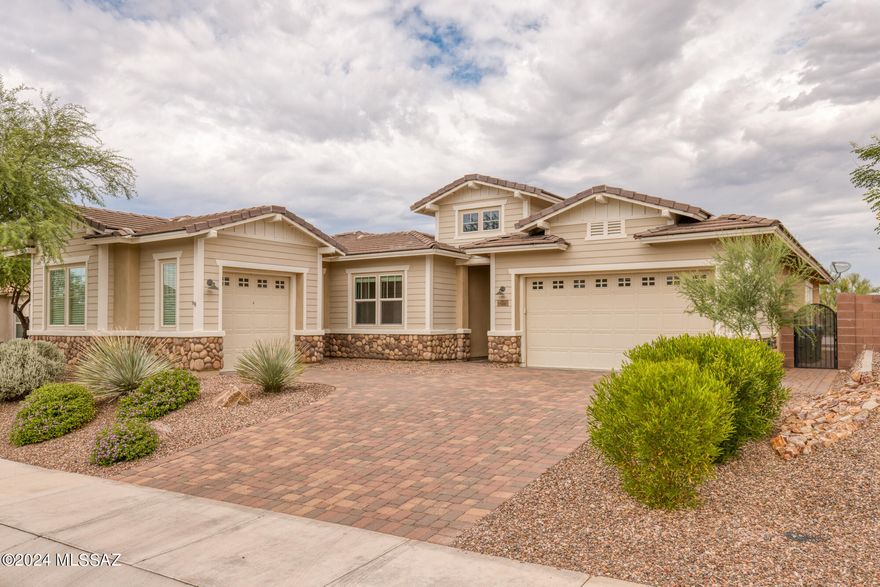 RANGE PRICED - Seller will accept or counter offers between $800,000 and $825,000.  This stunning home will have you enjoying Tucson home living at its best!  Located on a lot with a view in the beautiful gated Golden Barrel Place community at Dove Mountain, this bright and open home includes several desirable upgrades.  It has four bedrooms, two and a half bathrooms, a tandem three-car garage, and a bonus separate fourth car garage!  From the front entry, the paver driveway leads through the portico and into the sunny uncovered paver courtyard.  The inviting front doorway opens to the foyer where wood-look porcelain tile flooring begins running throughout the hallway and a large portion of the home. Sunshine is drawn in by plentiful windows displaying the natural glow of daylight. This home features a split floor plan with double door entry to a secluded primary suite with patio/pool access, which includes a broad window, facing mountain and desert views, large walk-in closet, luxury bath with soaker tub and roomy shower with upgraded shower tiles and glass shower doors.  There is a dedicated office/den with French doors, formal dining room, gourmet kitchen with oversized island, built in gas cooktop, built in wall oven and microwave combination, slab granite countertops, breakfast area, wet bar in the butler's pantry and a walk-in pantry.  The cabinets have upgrades of soft close drawers and roll out shelving.  The great room is open and substantial.  Ceiling fans are throughout.  What more would you need with zoned heating & cooling, a security system, fire suppression sprinklers and a LifeSource whole house water filtration system?  The laundry room has a washer, dryer and a sink.  All appliances convey with the home.  Upgraded landscaping in the backyard contains a covered patio with an outdoor ceiling fan, artificial turf, a planter,  sparkling saltwater pool system with waterfall, travertine pool deck, custom gas fire pit and recently painted stairs that lead to a bonus rooftop sundeck to enjoy the breathtaking views!  This beautiful home is just minutes away from the Ritz-Carlton, the Gallery Golf Club and the Golf Club at Dove Mountain, for those looking for an enjoyable active lifestyle. This home is move-in ready and set for you to add your personal touch!