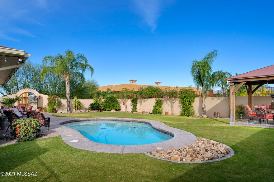 Beautiful custom home on over an acre in a quiet rural setting yet minutes from shops & restaurants. Enter through the lovely gates to a peaceful courtyard w/stunning mountain view. Welcoming mosaic tile foyer opens to large great room featuring floor to ceiling windows, expansive brick fireplace, polished ceramic tile floors & open concept living. Chef's kitchen w/SS appliances, gas cooktop, dual ovens & island w/seating. Nice split-bedroom floor plan w/primary bedroom located down private hall w/en suite bath & spacious walk-in closet. This home is made for indoor/outdoor entertaining w/French doors that open completely leading to the backyard oasis w/large grass yard, multiple seating areas, sparkling pool & covered ramada. 2-car garage & RV parking w/electric & dump facilities. No HOA!