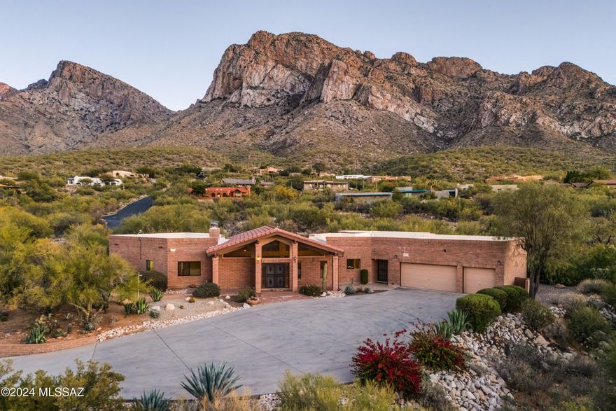 This listing includes the adjacent vacant .97-acre lot (220-15-5090) which shall be incorporated into any purchase contract on this property. Nestled on a 1-acre lot in the heart of Tucson, AZ, this exceptional custom-built slump block home offers a rare blend of elegance, comfort, and breathtaking natural beauty. Positioned to maximize the awe-inspiring views of Pusch Ridge and the Santa Catalina Mountains. This property is a desert sanctuary with unparalleled privacy. The open floor plan seamlessly connects the living, dining, and kitchen areas, creating a welcoming space filled with natural light. Enjoy a luxurious primary suite with mountain views, a spa-like ensuite bathroom with separate shower & soaking tub, and a large walk-in closet.  Two additional bedrooms and a powder room provide comfort and convenience. Bedroom #3 can be used as an office and/or bedroom. Relax on the enclosed patio, take in the sweeping mountain views, or enjoy the desert landscape surrounding the property. Located near hiking trails, golf courses, and Tucson's vibrant amenities, this home offers the best of Arizona living. Whether you're enjoying the stunning sunsets, mountain views or entertaining guests, this property is your personal desert oasis. Call today for your private showing!
