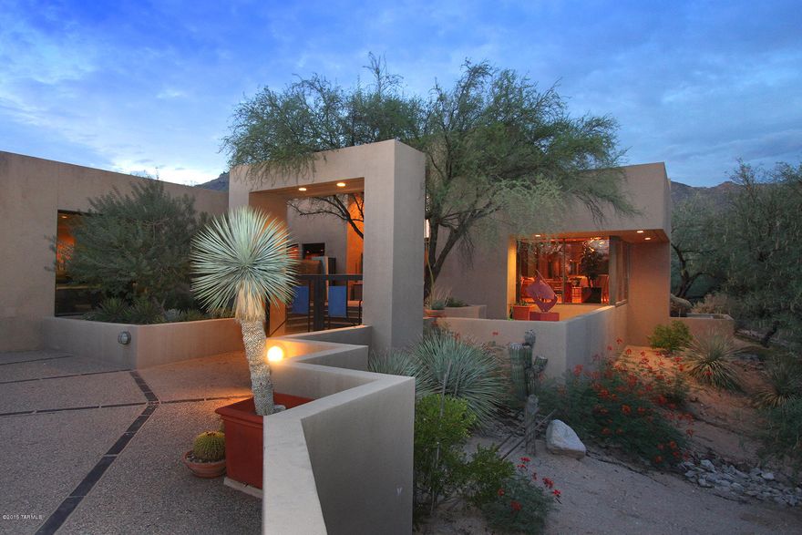 This elegantly stunning contemporary 4 bedroom 6 bath home epitomizes the gracious life in prestigious gated Ventana Canyon. Classically modern architecture blends with comfortable living spaces to create a perfect living environment suitable for the most discerning homeowners. One will not find anything overdone or fussy here, only the most tasteful dramatic simplicity. Bold striking architectural features greet you on arrival, with a backdrop of soaring mountains beyond. Glorious views of the mountains and the beautifully manicured golf course are framed by walls of windows throughout the home. From the moment one enters the handsome front doors flanked by a dramatic flowing wall of water and a striking outdoor sculpture, the quality and uniqueness of this home is apparent. The entry atrium hosts tall glass doors and windows focused on dramatic views of mountain ridgetops. In the spacious windowed living room there is ample accommodation for multiple seating areas, including a sunken bar area and granite seated wine bar and around the unique triangulated marble-ensconced fireplace. The formal dining room, also open to views of the bold rocky peaks, is ample and elegant for any sumptuous dining event. One entire wall is devoted to fabulous storage for serving and dining accessories, including multiple suede-like felt lined pullouts and tray storage separated by Lucite panels. A commodious sidebar of handsome dark granite tops the storage area, accented by large smoky mirrors that elegantly reflect diners and candles. Call the caterers, please! 
The family area, accented by a fireplace and backlit entertainment wall of storage and bookshelves, provides a cozy gathering space adjacent to the casual dining and open kitchen areas. These open outdoors onto an expansive east-facing terrace centered upon a dramatic water feature featuring a stainless steel and oxidized copper sculpture and overlooking the gently contoured emerald green fairway. With doves cooing at sunset, this is an idyllic spot for al fresco dining. Returning indoors, the kitchen space is defined by an angular black counter structure offset with richly hued taupe granite and overseen by a unique circular skylight. With matt-finish stainless steel Thermador 6 burner + griddle cooktop, 3 ovens, microwave, warming drawer, two custom inset sinks, 2 dishwashers and a generous side-by-side refrigerator& freezer, any chef would be gloriously happy. The oversized walk-in pantry, also graced with a unique skylight, has sufficient storage to provide sustenance for a small army of friends and family. The laundry room and hallway overlook a private enclosed patio bordered by the entry double-sided water feature and housing a lovely little cactus garden. 
A substantial foyer leads to the master suite encompassing a sleeping area that looks out upon another private patio and, through ancient mesquites, the gently rolling fairway. Adjacent is a spacious sitting area/exercise and yoga/office space, "Her" bath, and commodious closet with elegant custom built-ins. On the opposite side of the sleeping area is "His" bath and generous closet with built-ins. Two additional bedrooms with en suite baths, and a loft enjoying both east and west views and its own full bath, complete the living quarters. (Ask the listing agent to show the secret room hidden by a revolving panel!) The generous 3 car garage will accommodate multiple vehicles and "toys". This is truly a home that exudes sophistication and taste, a one-of-a-kind architectural achievement suitable for the most worldly of people. There is a current appraisal at $1,400,000 available upon request.