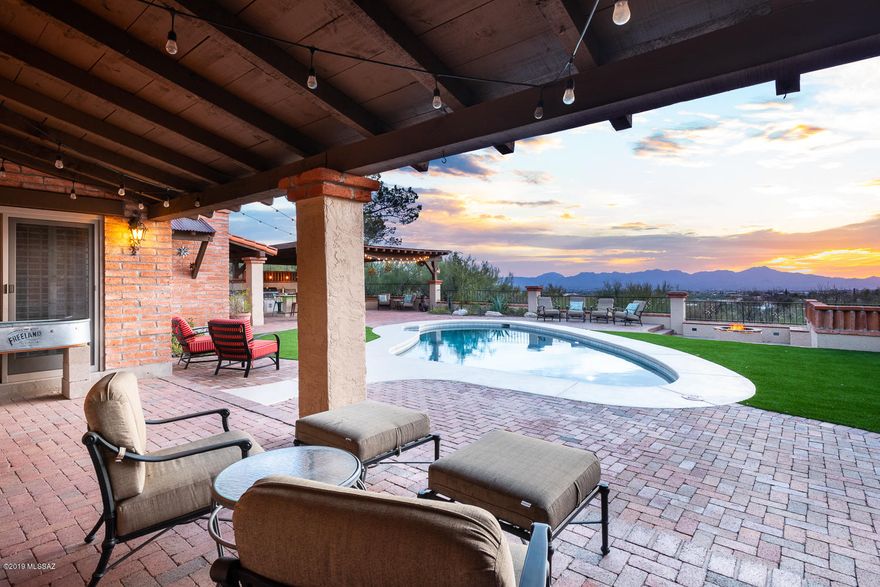 Charming remodeled home on .9 acre lot within walking distance of Manzanita Elementary School! Located in desirable Cat 9 this is a high-view lot w/ exceptional city, mountain & sunset views.  Remodeled kitchen w/ granite counters, SS appliances, upgraded cabinets & lighting, beautiful backsplash & views from every window.  Kitchen w/ breakfast bar & breakfast nook that is bright, spacious & open. Great room w/ cedar ceilings & FP is cozy & charming. Separate formal living & dining area has wood floors.  Additional bedrooms are spacious & additional full bathroom is upgraded & has dbl sinks.  Master suite has FP & doors to the patio & pool.  Master bath is upgraded w/travertine. Backyard is completely renovated  w/ new low-care turf, resurfaced & upgraded pool, and gas fire pit. & incredible new ramada & outdoor kitchen w/ BBQ.  Over-sized 3- car garage with extra storage. Truly unbeatable location minutes from La Encantada mall w/ Tucson's finest restaurants & shopping, La Paloma Resort & Country Club and other world-class golf resorts. District #16 schools.