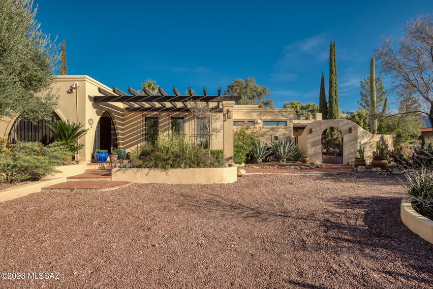 Enchanting hacienda located in Catalina Foothills Estates No. 5. Stroll the private, curated outdoor gardens, a labyrinth of  1.3 acres with a magical, lush breakfast garden; classic wood-burning beehive FP garden with banco seating; an expansive pool and lounge area with a rock waterfall fountain, entertaining ramada, and built-in gas BBQ with tiled counter; visit the sunset deck via exterior staircase to experience panoramic city sunset views.  Enter the elegant home by way of a charming Arizona room, the perfect quiet location to experience sunrise and birdsong. Step into the resort-style grand foyer with glass ceiling and feel yourself relax (CONT...) as this space opens into a formal living room, a den with fireplace, and an elegant study with wet bar. The renovated kitchen has everything for a gourmet chef: professional range, wine fridge & ice machine, island, desk & dining area with doors to the pool and views of sunrise over the Rincon Mountains. A formal dining room has garden views and custom built-in sideboard and window seat. The peaceful, elegant primary bedroom has patio doors and plantation shutters overlooking the gardens and the Catalinas. A total of 4 bedrooms & 3 full baths, bonus office room off of the primary bedroom, and large laundry & mudroom provide many opportunities to create your dream living spaces. Come and experience the magic. This home is like no other, a private retreat or an entertainer's paradise. Close to UA, 15 minutes to downtown museums and nightlife, walk to the best dining and luxury shopping in Tucson at La Encantada, near world-class golf courses, tennis and easy access to Tucson's Loop for biking and walking. 
Extra highlights include: Fully owned Solar; Newer pool heater and chiller; refurbished roof with warranty; new water pipes; 3 new dual flush toilets; room to add casita/guest house, and more. Must See!