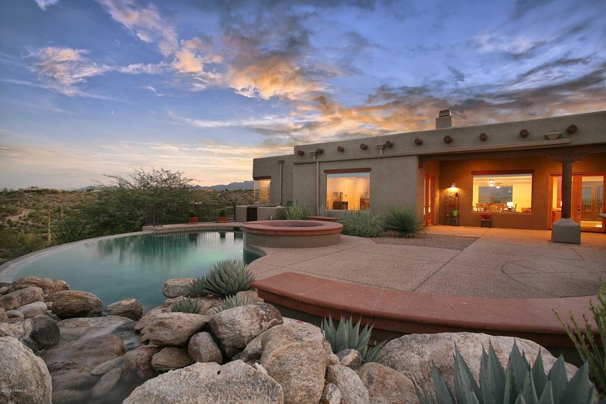 Awe-inspiring views greet you from the moment you walk in this gorgeous Santa Fe home w/incredible backyard offering City lights, the majestic Catalinas, negative edge salt water pool, spa & water feature plus a huge covered patio for the best in outdoor living. Charming front courtyard leads you through the dramatic iron & glass entry door into the spacious open flrpln w/high ceilings, viga beams, travertine floors and rich alder doors and cabinets throughout. Every window offers a wonderful view! Kitchen has high-end stainless appliances incl wine fridge, granite, large island & a generous pantry. Wonderful master suite with fireplace, his & hers closets and an amazing bath with full body shower + Jason hydrotherapy tub. Premier gated community, huge laundry room & oversized 3-car garage