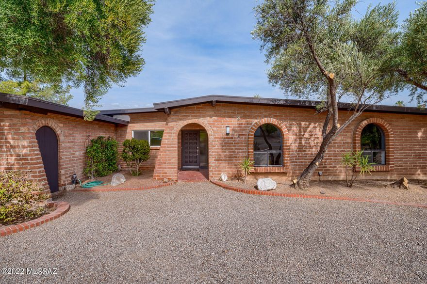 Classic & ever desired burnt adobe brick ranch style hacienda. Located in the Catalina Foothills in the shadows of Sabino Canyon. This 4 bedroom 2.5 bathroom with pool & 2 car garage has been re-imagined to meld modern design/finishes while keeping the charm of yesteryear. Full custom kitchen with wood beam ceilings is perfect for entertaining. Home has two additional living spaces in living room and dining room. Primary suite has sought after size and space in both great bathroom and custom closet. Split bedroom plan has additional 3 large bedrooms with hall bath. Laundry room provides storage and great utility. This home checks all the boxes and ready for new owners.