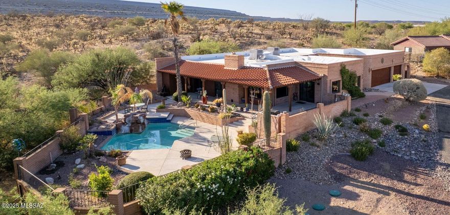 Combining luxury and privacy, this custom home on 1.2 acres features unobstructed mountain views with a backyard oasis with a cascading waterfall, pool, and wrap-around covered patio.  From within, revel in the open floor plan flowing into the chef's kitchen featuring a ILVE Majestic gas range, abundant cabinet space, walk-in pantry, and a huge island bar.  An entertaining dream!  Main areas included dining and living areas with a separate den/media room.  Owner's suite leaves nothing to be desired - patio/pool access, a step in shower, dual vanities, and three closets.  A full bathroom to accompany the second bedroom, plus a guest quite complete with a full bathroom and a separate den or office space.  A over-sized three car attached garage with hallway and front entryway access.