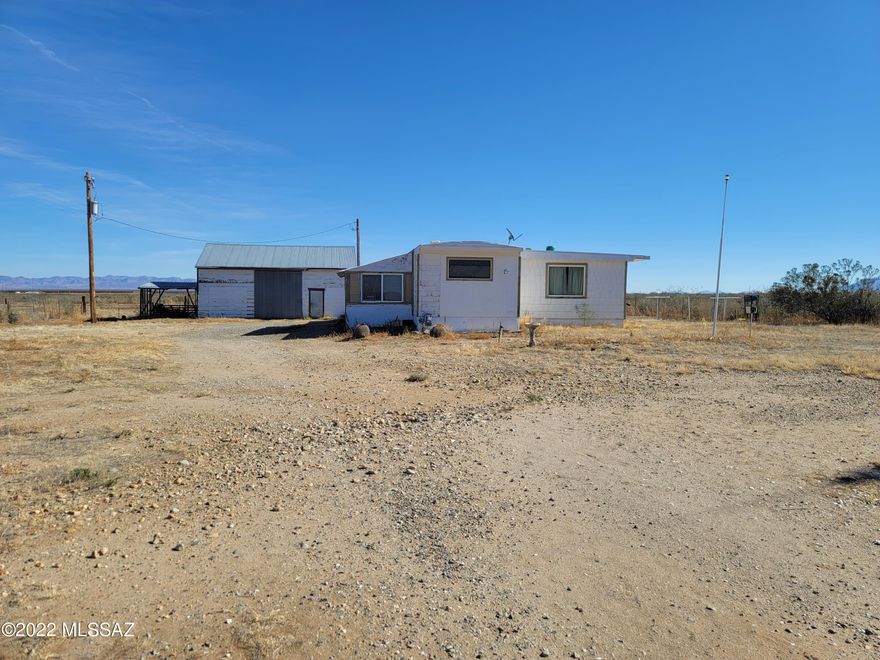 BOWIE, AZ -County Retreat.  This 3 bedroom 1 bath Manufactured home is waiting for you to create a Home away from Home.  Bring your Animals and RV and enjoy the Sunshine and warm Weather!  The property consists of 21.12 Acres, Multiple Storage Sheds/ HUGE Shop / Barn with Loft and 2 separate sides to divide the Storage and work space, NEW Well installed  in 2016 @ a Cost of $17,728 - 640 feet deep/ Static water 518'/ Well Casing to the depth of 593'. This property used to be a Watermelon Farm.  There is an Old irrigation well that is Non-Functional still registered and on the Property. 
Property is sold in AS-IS Condition, All personal Property will remain. Cash and Conventional Loans only due to age of Manufactured Home.