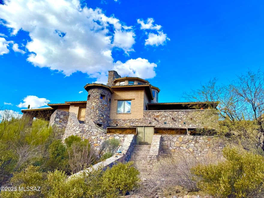 Wow!!! Check out one of the most unique homes you'll ever see located on 15 acres of pristine untouched desert in the Tucson Mountains. Built from the Rhyolite of the earth surrounding it, this amazing structure is reminiscent of a castle with 8 fireplaces, multiple secret rooms, a tower loft, a Kiva, and even an underground wine cellar! Every side of the home has outdoor living space with many covered patios, hidden grottos, balconies, and decks to admire the nature you are immersed within. Bound on each side by National Park land and the University of Arizona Desert Research Station land gives you total privacy without the fear of anyone building next to you. Or you can split the lot to build several more homes! Bring your vision to put the finishing touches on this solid masterpiece! Listed as a fix up due to the unfinished flooring in some rooms, an unfinished bathroom, and many missing lighting fixtures. A little bit of personal touch will go a long way to customize this home and make it your own!