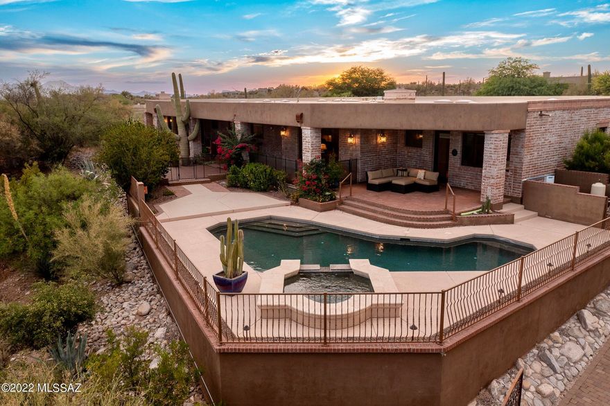 Surround yourself in new heights of luxury at this stunning Mediterranean burnt adobe home. Tucked away on a secluded lot, you will enjoy the immense mountain views & sparkling city lights. Upon entry, the long paver driveway will lead to a courtyard with soothing rock water features and a beautiful iron door that opens up to a combination of textures, finishes & a warm palette of unmatched architectural mastery. The dedicated living spaces include: an office with custom carved bookshelves, a formal dining area featuring a wine wall & a family room with a wet bar. The Gourmet kitchen, perfect for any chef, boasts an oversized center-island, rough cut edge granite countertops, stainless appliances and customized vent. The primary suite finds a cozy fireplace, large walk-in custom closet & access to a private patio to enjoy all the sunset views. There are three additional en-suite bedrooms & one with its own covered patio. This site was beautifully designed for indoor/outdoor entertainment with resort style living. Retreat outdoors to multiple covered patios, a refreshing pool & spa, 2 fire features plus a putting green.