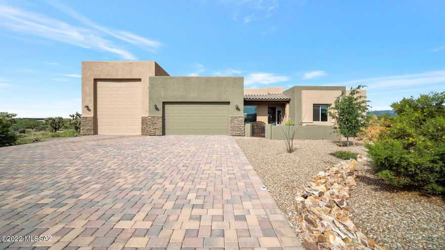 Where the beautiful landscape of the Sonoran Desert, meets custom built homes in a gated community, you will find this amazing, modern finished home. Built by Cornerstone in 2020, the paver driveway guides you to an expansive courtyard to soak in the majestic views of the Santa Rita Mountain range. Step inside to a master planned 2270sft home with 4 bedrooms, 2 and a half bathrooms, curved architectural wall and window details, offering mountain views from nearly every angle. The gourmet kitchen features designer 42-inch upper cabinetry with crown molding and roll out shelves, a spacious pantry closet, gas cook top with stainless steel hood, and upgraded granite counters. This open concept floor plan allows you to entertain to the fullest. The main bedroom features a sliding glass door to the perfectly situated hot tub to unwind and enjoy the breathtaking sunrise and sunset's southern Arizona has to offer. Step into the main un-suite offering quartzite counters, imported hand blown dual vanities, a large walk-in tile shower with solar tube and dual walk-in closets providing an abundance of storage. This split bedroom floor plan offers privacy and comfort for families and guests. A jack and jill bathroom with quartzite counters and imported hand blown sink joins two of the bedrooms. Enter the 4th bedroom through a double door entrance, which also makes a wonderful office space with mountain views. Step outside to the extended patio encompassing 68ft of covered patio space with ceiling fans to keep you cool on warm summer days. The backyard also includes master designed landscaping with gas fire pit, artificial turf, and a  therapeutic hot tub. The attached garage has a 3-car tandem and a 14ft by 46ft RV garage with full hook up, including 50amp service and dump. This extravagant property is ready for you to make your own.