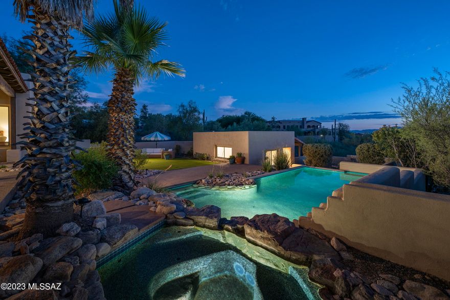 Enjoy Catalina Mountain views, city lights, and fabulous sunsets from this hillside residence on a private cul-de-sac within the gated community of Colonia Del Sol. The courtyard entry leads to a flowing floor plan that includes a sunken living room, dining area with coved ceiling, and spacious family room featuring a beehive fireplace and walls of windows. The spacious kitchen offers gorgeous solid wood cabinetry, Corian countertops, Saltillo tile floors, and a light-filled breakfast nook with captivating mountain views. The split layout of the residence provides a private primary bedroom sanctuary offering a spa-like bathroom with jetted tub and separate shower, large walk in closet, and sliding glass doors leading to the patio. The balance of the 3 bedrooms and 2 full bathrooms in the main home are sequestered on the opposite wing, perfect for families or guests alike. 

The privately situated guest casita offers a spacious bedroom area and kitchenette, bathroom, and a private covered patio to enjoy the sweeping views. 

An expansive main-house patio connects the shared living spaces, ideal for seamless indoor-outdoor entertaining or al fresco dining. Layers of elevated lounge areas create the framework for the luxurious PebbleTec pool and spa, acting as the centerpiece of the backyard. 

Ultra-privacy meets convenient proximity to all of life's necessities. From this central Foothills location, one is just moments away from hiking and biking trails, Hacienda Del Sol Resort, La Paloma Country Club, and La Encantada's shops and restaurants.
