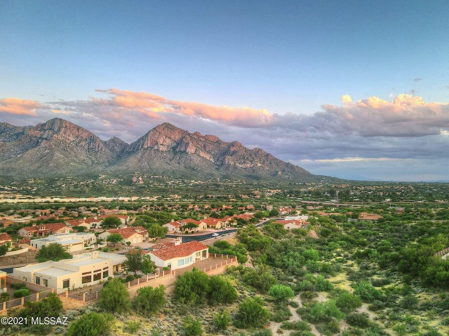 Sellers to counter/entertain offers between $850,000-$900,000. With a backdrop of unobstructed desert and mountain views, this impressive Sombra-built home beautifully reflects the Sonoran desert lifestyle! Serene outdoor spaces are perfectly situated to take advantage of Pusch Ridge and Tortolita Mountain views, with a private front courtyard and picturesque backyard highlighted by custom paver-laid patios and walkways, and an elegant outdoor fireplace inviting you to sit back, relax, and embrace the outdoors. Iconic architectural
interest and sophisticated details throughout the interior of the home, including tongue-and-groove wood plank ceiling complemented by gorgeous vigas and corbels, elegant arched doorways, and handsome 4' stamped-concrete flooring. Anchoring the home's dynamic floorplan and offering grand views upon entry to the home is a light-filled great room showcasing a trio of picture windows overlooking the backyard and framing phenomenal desert and sunset views! Designed with the home chef in mind, the open kitchen is equipped with double wall ovens, five-burner gas cooktop, Bosch dishwasher, an abundance of counter and
cooking space, and expansive bar-height counter with seating for up to 8; a light-filled dining nook and inviting formal dining room are located nearby for extra dining or entertaining space. The sprawling primary suite is a resort-like retreat with private patio entry, sitting area with fireplace, and luxurious ensuite bath. Flexible-use den located off the front entry and three additional bedrooms with walk-in closets provide ample room for all of your needs!