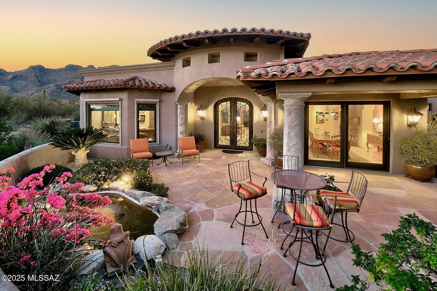 Nestled in the prestigious guard-gated community of Pima Canyon, this exquisite Santa Barbara-style estate, designed by Greg Simmons and built by Bill Diamond, offers unparalleled elegance and breathtaking mountain and city views. A long private paver driveway leads to a gated courtyard, setting the stage for the grandeur within. Step into the foyer and be captivated by walls of windows showcasing the stunning desert landscape. Exposed wood beams, corbels, and a custom masonry fireplace create a warm, inviting ambiance in the living room, seamlessly flowing into the formal dining area with doors that open for effortless indoor-outdoor entertaining. A wet bar perfectly positioned between the living room and kitchen enhances the home's entertainment appeal. The gourmet kitchen features a crackle-finish on the island, a coved ceiling, and top-tier appliances, including a Viking 6-burner gas cooktop, Dacor double ovens, a Sub-Zero refrigerator, and a new microwave/convection oven. The luxurious primary suite boasts a masonry fireplace with a raised hearth, a bay window, coved ceilings, and a spa-like bath with two walk-in closets. A spacious office with custom built-ins offers inspiring views. Outdoors, a flagstone patio, soothing water feature, beehive fireplace, and lush landscaping create an idyllic retreat. Recent updates include fresh exterior paint, two new air conditioners, a new washer and dryer, and a new irrigation system, ensuring this masterpiece is impeccably maintained.