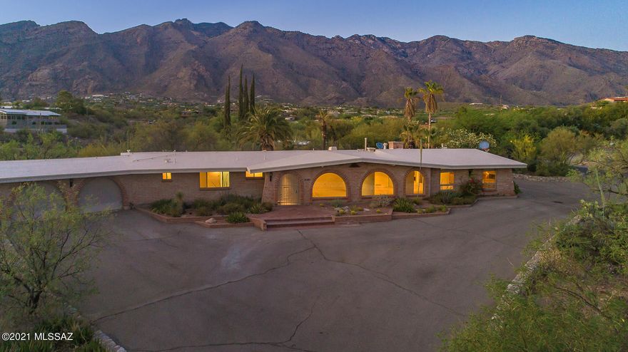 Classic Territorial Home in the heart of the Foothills, Skyline Bel Air Estates!!   This beauty sits on a 1.53 acre with scenic views of the City & Catalina Mts.   Spacious entry leads to living/dinning rooms with wall of windows  custom ash cabinetry built ins throughout, Travertine tile, Over sized game/billiard room & bar,  loads of cabinet and counters space in this custom built kitchen with granite counters,  breakfast area over looks family room with fireplace & bookcase, Master suite has custom built in closet & double vanities, laundry room has storage and 1/2 bath for swimming pool use, charming patio and pebble tech pool,  Built in gas BBQ.  Westside gate access to garage.  Community Pool & Tennis courts too! 1/2 acre behind has separate tax code. Come take a look