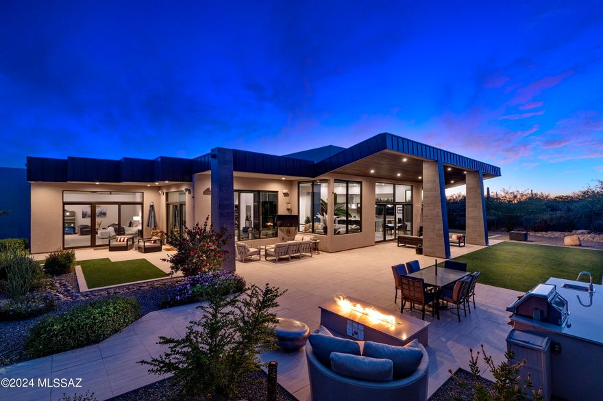 Unfolding across the 1.48 acre custom homesite and situated behind the secondary gates of the exclusive Reserve at Pima Canyon enclave, this incomparable residence demands privacy while preserving views that open out to far reaching vistas of the adjacent Catalina Mountains. The home's architectural identity is defined by the striking anodized steel roof cladding, juxtaposed against Dryvit plastered walls, presenting a visual and compelling composition of both horizontal and vertical form. Spanning the 5,378 square foot split bedroom floor plan, the home's layout flows continuously with the topography, while the backyard adapts to the gentle cant of the nearby hillside. Volumes of shifting scale, with walls of windows expose resplendent natural light, while simultaneously maximizing the Catalina Mountain views at every turn.

Upon entry, one is greeted by a foyer with soaring ceiling heights, establishing the main connection point of the home, which opens onto the great room, consisting of a living room, dining, and a chef's kitchen. The kitchen, acting as a center point of the home, is not solely a culinary workspace, but invites its users to engage in the rituals of daily life. Tones and textures, juxtaposed against natural stone and custom millwork create an intrinsic beauty found in the authenticity of the materials. At the heart of this epicurean experience is a suite of professional Wolf and SubZero appliances that merge functionality with a design-forward sensibility, elevating the art of the culinary experience.

Accommodations are split across the primary level, with four ensuite bedrooms, a dedicated office/media room, and guest powder room. The primary suite is concealed on the East wing of the property, complementing the home's design ethos, where style and functionality coalesce. Every detail has been carefully considered, from the proportions, to the choice of materials, with millwork that seamlessly integrates within the space, while maintaining an aesthetic that resonates within the broader design narrative.

The property accentuates the indoor and outdoor lifestyle, having been masterfully designed for entertaining, with layers of elevated patios creating the framework for the pool and spa acting as the centerpiece of the backyard experience. The scale and grounds have the feeling of a boutique resort, with pavers that connect the various social spaces, which include a Napoleon barbeque station, gas fire pit, and large covered verandas perfect for al fresco dining.

Ultra-exclusivity meets convenient proximity to all of life's necessities. From this central Foothills location, one is just moments away from hiking and biking trails, La Paloma Country Club, La Encantada, and Casas Adobes shopping and restaurants just to name a few.
