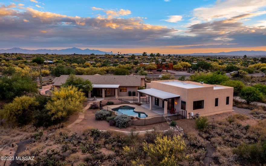 Premier location along the Old Spanish Trail scenic drive, adjacent to Saguaro National Monument w/lush desert landscaping. This home has stunning views & an abundance of privacy. The main house features 2 primary suites + an extra bedroom, 3 full baths & vaulted ceilings which allow plenty of natural sunlight to shine thru creating an inviting atmosphere you won't want to leave. The spacious guest house has 2 BR/1.5 BA + a living/dining area allowing for so many options: multigenerational living, home office, rental income or seclusion for your house guests! Step outside to the refreshing pebble tec pool & soothing waterfall surrounded by many saguaros & natural desert scape. Generous 2 car garage & expanded covered patios complete this one of a kind home that sits on a huge 3.6 acre lot!