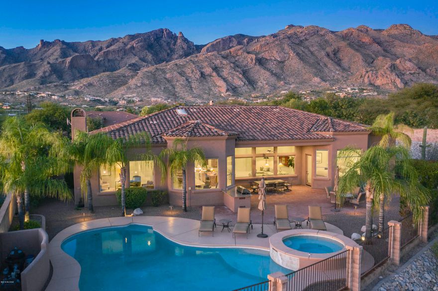 Stunning soft contemporary w/mountain, city & sunset views in desirable gated Pinnacle Ridge. Front courtyard  entry, exquisite living room w/high ceilings, walls of dramatic picture windows, formal dining room, gourmet island kitchen w/granite countertops, gas stove top, refrigerator, double ovens, pantry, large family room, lovely breakfast area that opens to family room w/fireplace,  beautiful tile flrs, 3 BR's+ study w/built in bookcases or 4 BR's, 4 baths including master w/sitting area, bath w/designer tile countertops, double sinks, garden tub, shower, 2 large walk in closets & private entry rear patio. Enjoy fabulous bkyd w/cov'd brick patio, pool, spa, BBQ, lush landscaping, 3 car garage,  Dist.16 school & incredible  city & mtn views. Floor plan under photos/virtual tour.