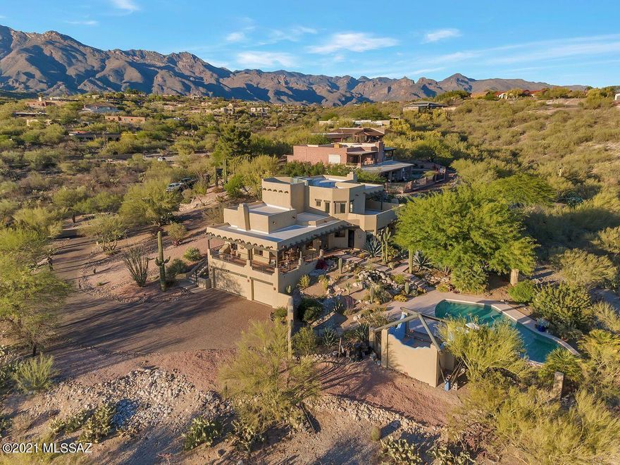 Beautiful southwestern foothills home with unobstructed views of the city & mtns. This Sante Fe has a resort like yard with pebble tec pool, cozy sitting area and recirculating waterfall. Latillas  Ramada shades the gas BBQ area. The wrap around patio is perfect for appreciating Arizona's sunsets. Custom double iron doors open to the yard. Catalina mtn views from the living room w/custom carved corbels & Vegas, high ceilings & fireplace. Separate family room has custom Sante Fe style fireplace. Solid alder doors throughout. Custom pavers on driveway. master suite w/fireplace, remodeled bath & viewing balcony. Wood lintels above every window & door. Zoned irrigation by plant type. Split system in 3 car garage. Convenient to TMC, Whole Foods, park, shopping & Basis school.