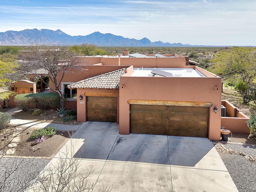 Magnificent mountain views and ''Old World'' styling set the stage for this grand estate. As you approach the home you will see the impressive Santa Rita Mountains towering behind the house!  The highly specialized integral stucco finish on the home is uniquely beautiful and does not need to be painted!  Sitting on 1.5 acres,  acres, the outdoor living spaces, privacy and views of this home are unsurpassed. A huge front courtyard offers more Old World charm and verdant landscaping. A beautiful gurgling fountain greets guests. Inside, the great room is magnificent with soaring ceilings and walls of glass looking out to the mountains.  A roaring beehive fireplace anchors the room and adds ambience.
The back patio will be the place for friends and family to gather, creating memories and gazing at the mountains. A sparkling, small pool is perfect for cooling off in the warm desert afternoons.  Step inside to the great room through large, wood framed sliders which can be opened to blend the inside and outside living spaces. Stunning carmel colored cement floors throughout the house give it an elegant and elevated look. The kitchen exudes luxury with  a huge center island and top of the line appliances, including a Viking range and refrigerator.  Open shelving is convenient for the chef and displays all of your favorite treasures, and highly customized, sand-blasted cabinetry gives a nod to the taste and artistry of this home.  A breakfast nook is perfect for morning coffee and a separate dining room plays host to more formal events.  A large den is open to the living areas but can be closed off for privacy.  The master bedroom windows frame the mountain views. A spa like bath features split vanities, a soaking tub, walk-in closet and walk-in shower. The guest en-suite is spacious and private. Whether your lifestyle is based on family, entertaining, or both, this elegantly designed and artful home is meant for a passionate and discriminating owner who is ready to embrace the modern desert lifestyle!