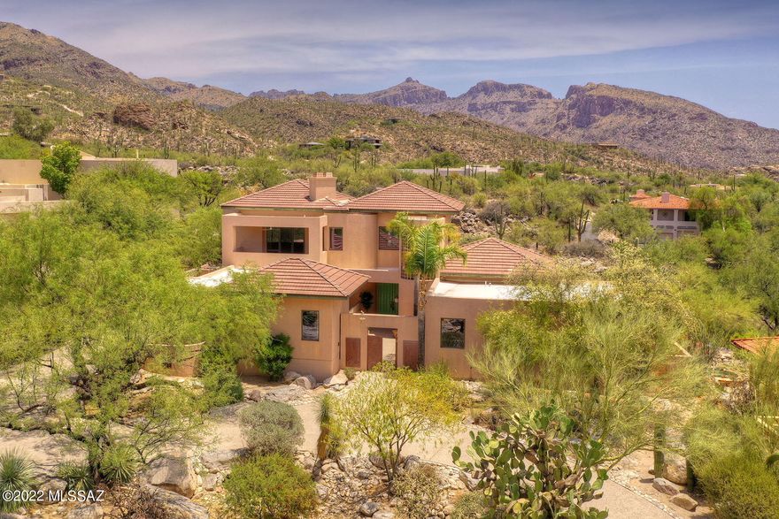 Creatively designed custom home on one of the finest lots in prestigious Ventana Canyon with sweeping mountain, canyon, city & golf course views. This expansive 4583 Sq Ft floor plan offers a formal dining room, large kitchen, 4 bedrooms, 4.5 Bathrooms, exercise room & living room with tongue and groove ceiling. The upstairs primary suite, accessed via stairway or elevator, has views from every window & contains a cedar closet plus huge walk-in closet and is accented by two covered balconies ideal for capturing sunsets & city lights. 3 additional bedrooms located downstairs, include a guest quarters ideal for caretaker or nanny. Wall to wall windows capture amazing views and look out to backyard with infinity pool that overlooks Esperero Wash. 3-car garage with workshop.