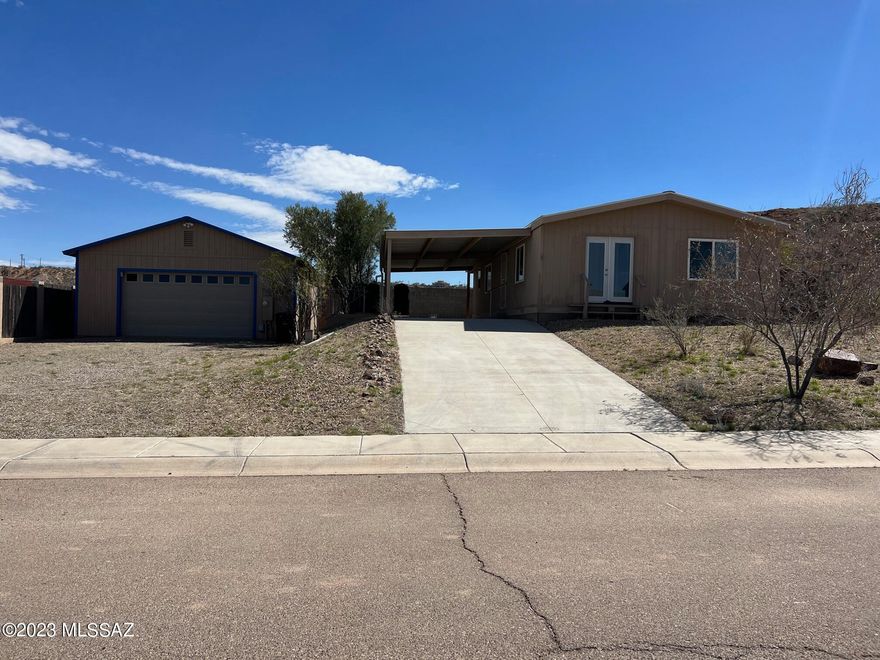What a find!  Well kept home with a 780 sq ft insulated garage with heating and cooling.  Home offers an open bright floor plan, nice hardwood floors and  all the appliances stay! West windows have solar shades on windows.  Garage has a kitchen and bathroom with a shower.  Metal roof on both buildings.  A few shaded sitting areas to enjoy the outdoors.   Hugh water tank for  rain harvesting off the roof.    Back gate opens up to a trail for hiking.   No HOA! Close to shopping.